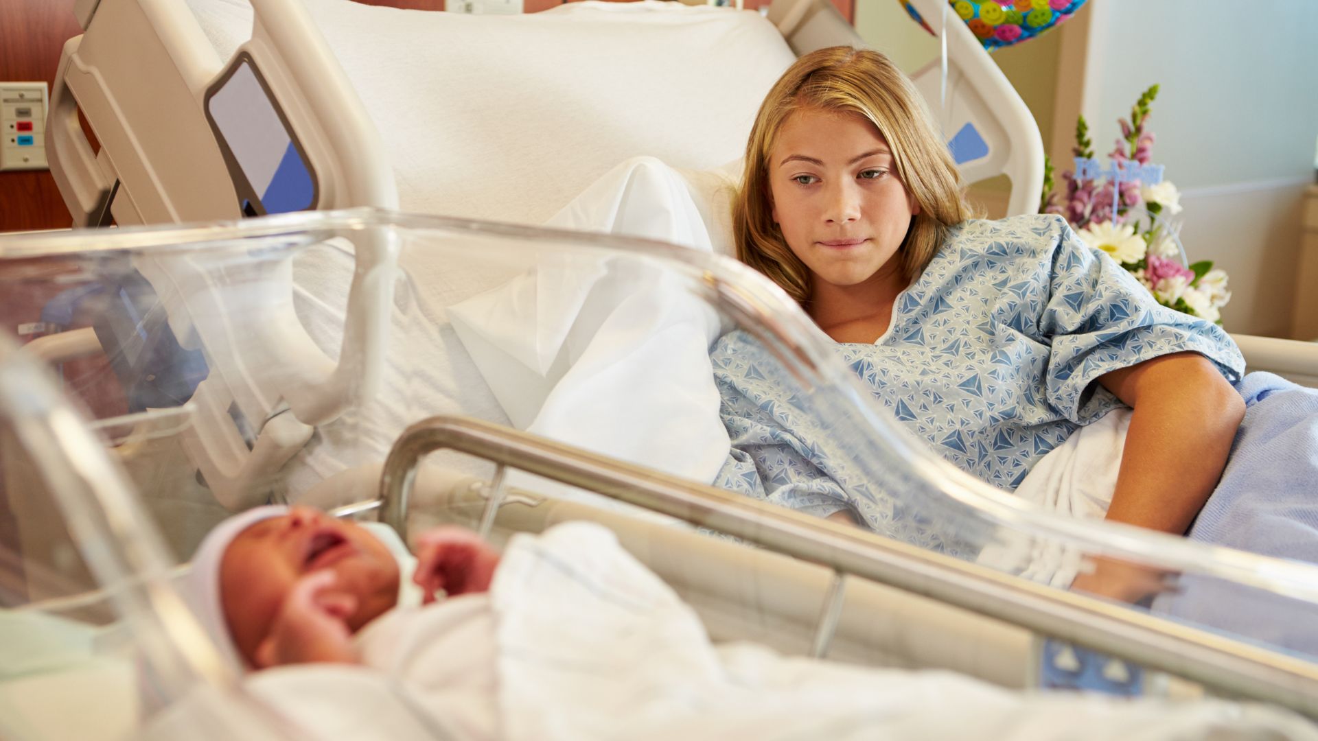 teen mom with newborn baby in the hospital 